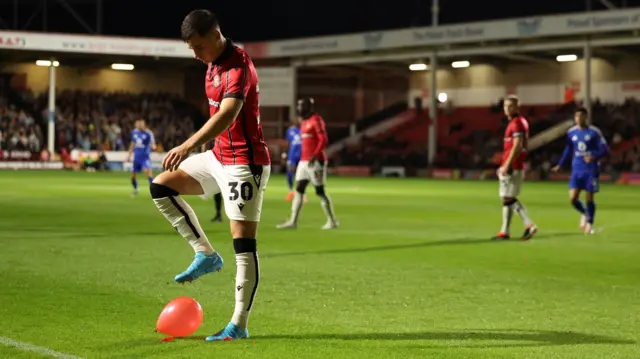 Evan Weir of Walsall stamps on a balloon