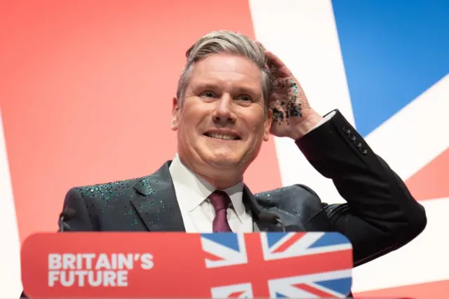 Starmer brushing off the glitter after a protest at last year's conference