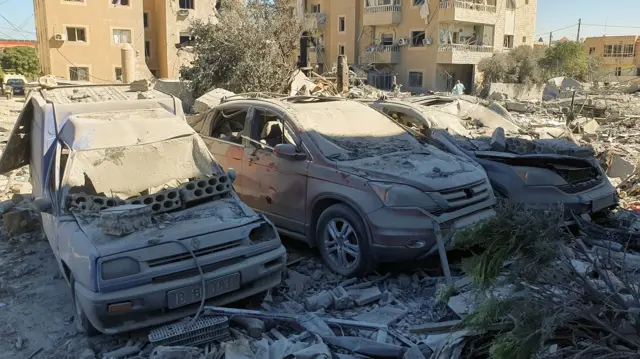 Vehicles crushed under falling debris from nearby buildings