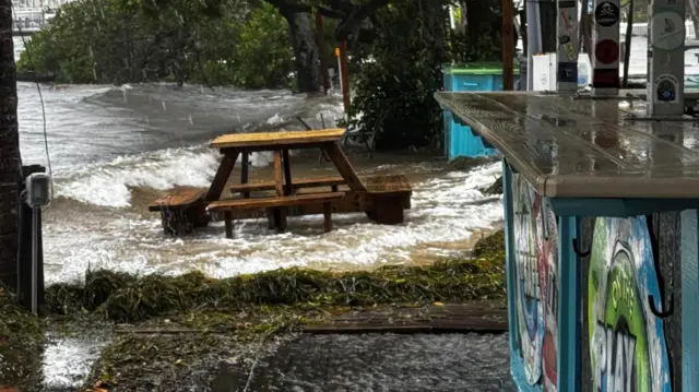 Water is seen creeping up to a restaurant on Anna Maria Island in Florida