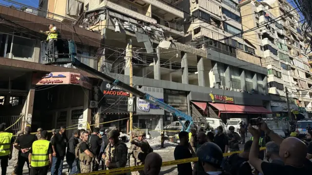 Lebanese soldiers and residents stand in front of the damaged building