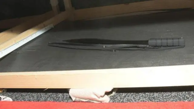 A machete lying under a bed