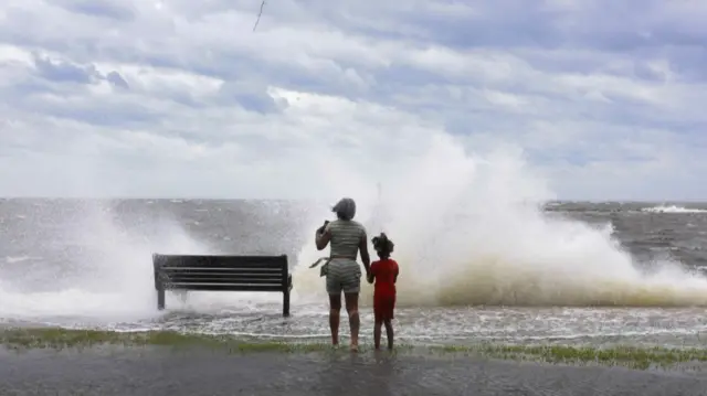 Two people are sprayed by ocean waves in Florida