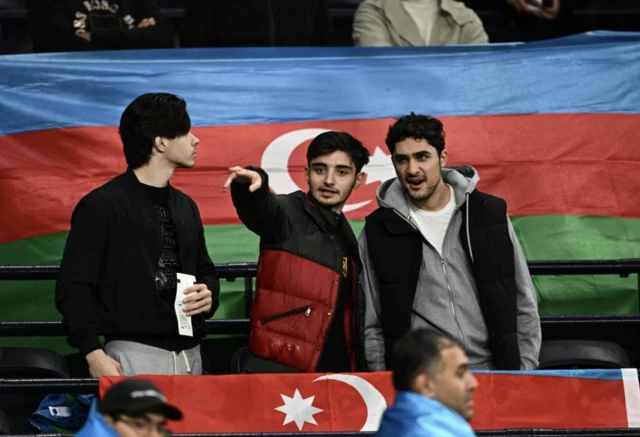 A Qarabag fan displays the Azerbaijani flag in the stands