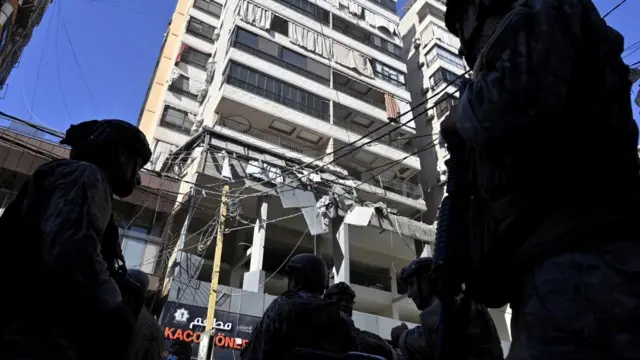 Lebanese soldiers stand outside a building damaged in an Israeli air strike on Beirut