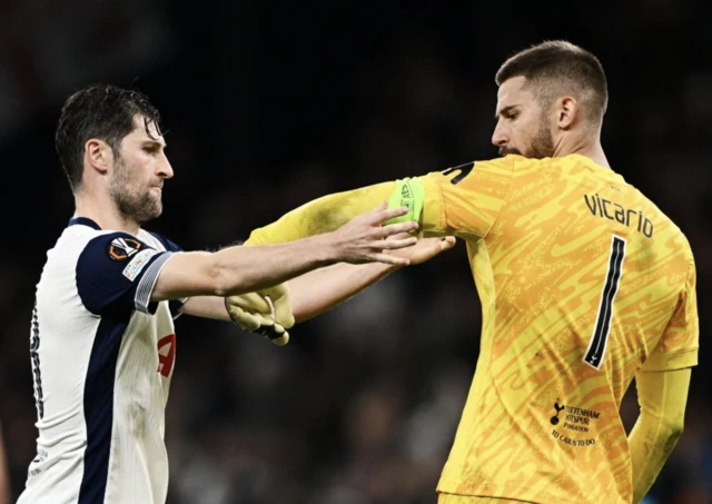 Tottenham Hotspur's Ben Davies gives the captains armband to Guglielmo Vicario