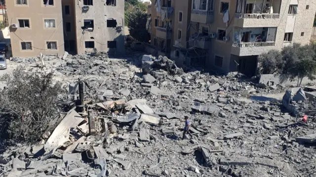 A man walks over rubble