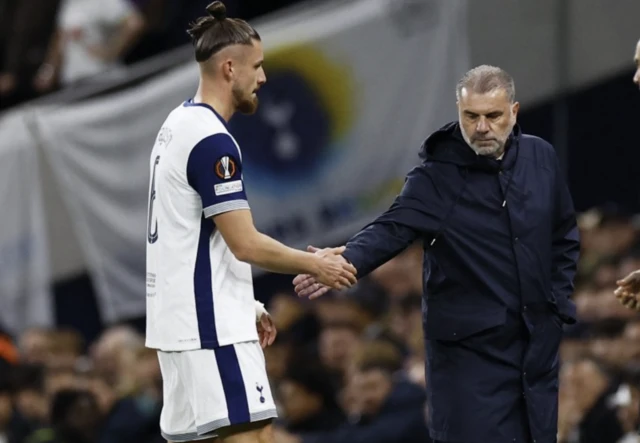 Radu Dragusin shakes hands with manager Ange Postecoglou