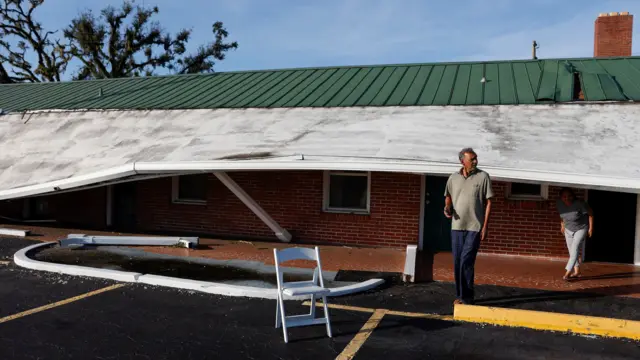 People stand outside of a motel amid damage from Hurricane Helene in Perry, Florida