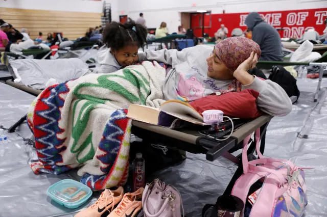 Eriya Lockley, 4, spends time with mother Ebony Lockley while both take shelter from Hurricane Helene at Leon High School near downtown Tallahassee, Florida,