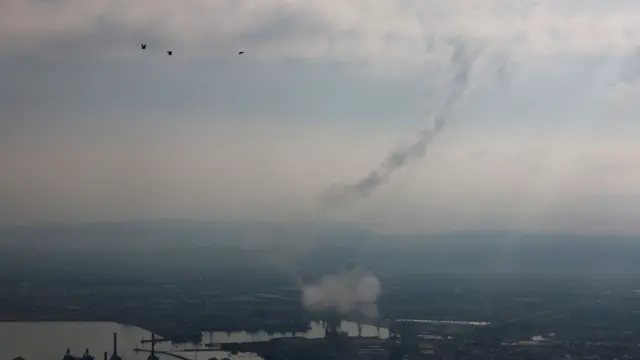 Smoke rising from the ground into a murky sky