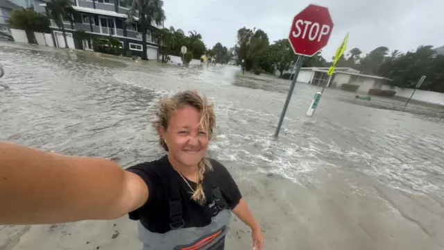 Briana Gagnier wades through the flooded streets of Holmes Beach in Florida