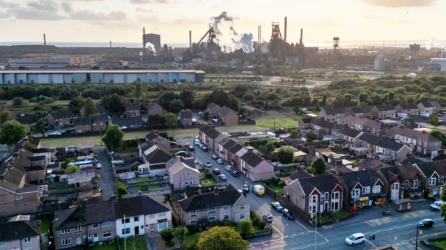 Aerial view of Port Talbot, with the steelworks behind many houses