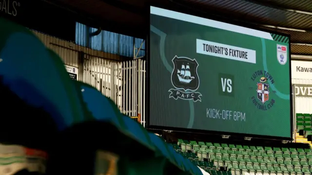 The big screen at Home Park shows the badges of Plymouth Argyle and Luton TownL