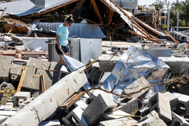 Roys restaurant worker searches through the rubble at the demolished restaurant after Hurricane Helene landed in Steinhatchee, Florida,