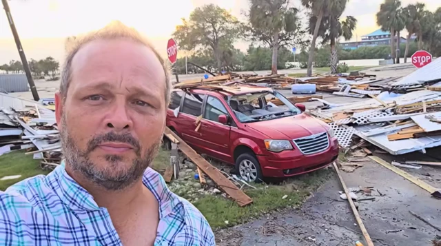 Michael Bobbit, a Cedar Key resident, takes a selfie in front of flattened homes