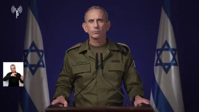 Daniel Hagari at a podium wearing military fatigues