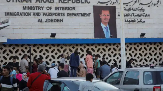 People queue in front of the Ministry of Interior Immigration and Passports department