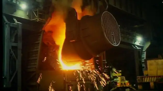 Steelmaking in process, with sparks and flames coming off machinery