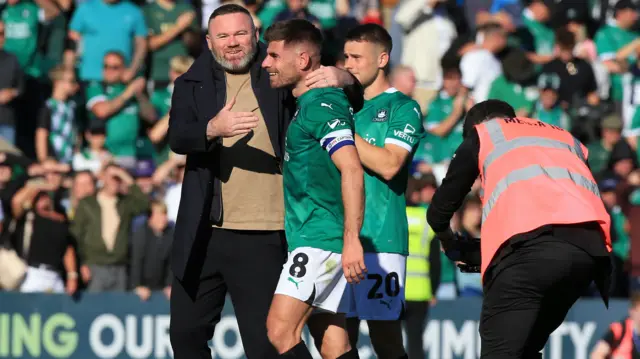 Wayne Rooney celebrates victory over Sunderland with Plymouth captain Joe Edwards.