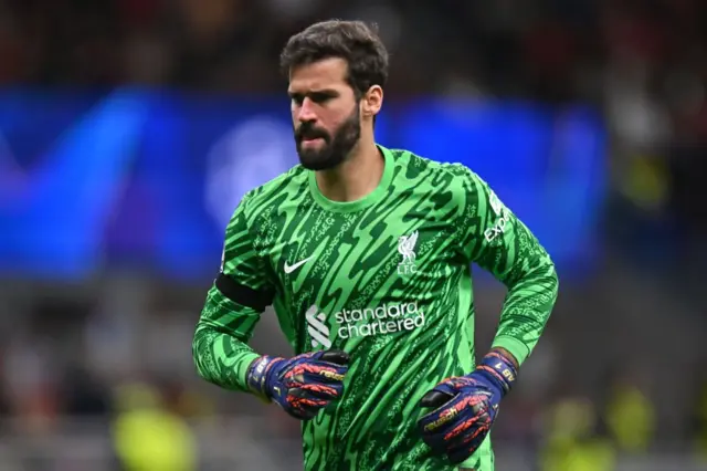 Alisson warming up in his Liverpool kit