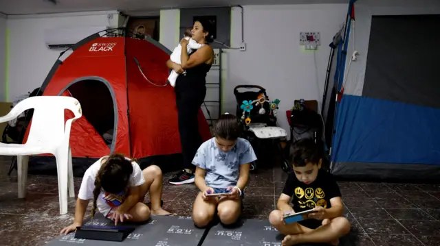 Israelis stay in a bomb shelter following rocket attacks from Lebanon towards Israel, in the town of Acre