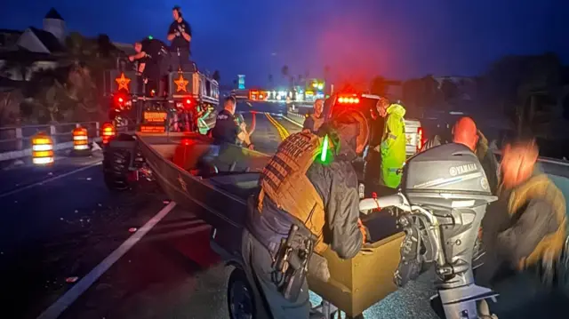 Night-time scene of people on a rescue boat rescue boat at Fort Myers Beach