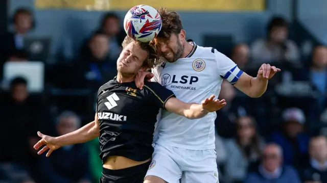 Bromley's Callum Reynolds and Tommy Leigh of MK Dons compete for the ball