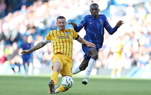 Lewis Dunk of Brighton & Hove Albion is challenged by Nicolas Jackson