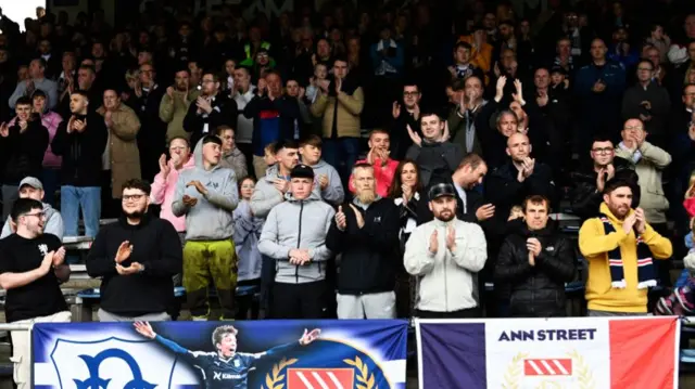 DUNDEE, SCOTLAND - SEPTEMBER 28: Dundee fans during a minutes applause in memory of former Dundee forward Fabian Caballero who passed away aged 46 during a William Hill Scottish Premiersihp match between Dundee FC and Aberdeen at the Scot Foam Stadium at Dens Park, on September 28, 2024, in Dundee, Scotland. (Photo by Rob Casey / SNS Group)