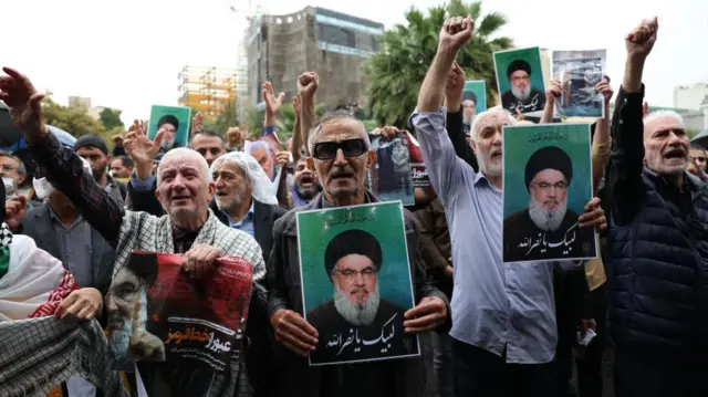 Protesters hold pictures of late Hezbollah leader Hassan Nasrallah during an anti-Israel protest in Palestine Square in Tehran