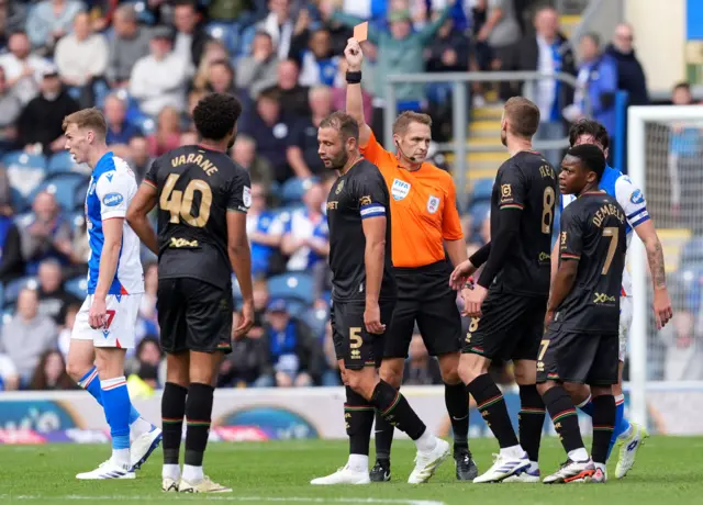 Referee Craig Pawson shows a red card to Queens Park Rangers' Jonathan Varane