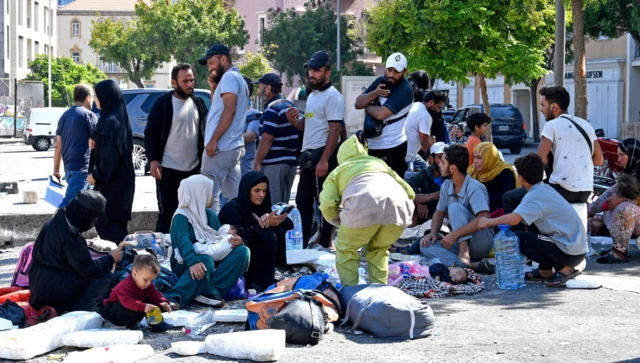 A crowd of people congregate in a pavement in downtown Beirut