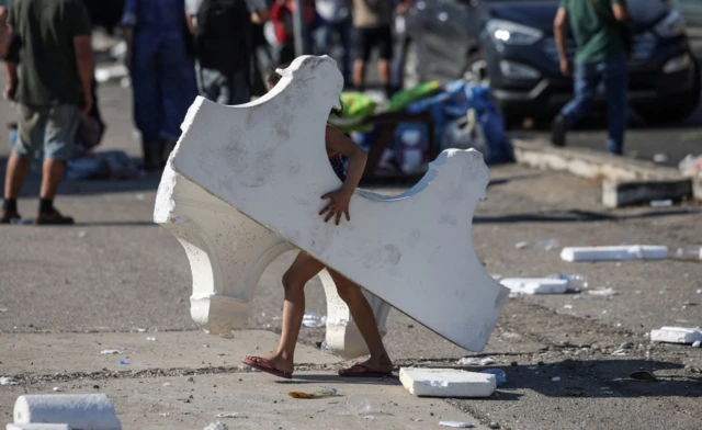 A child carries Styrofoam pieces to use them for shelter in Beirut