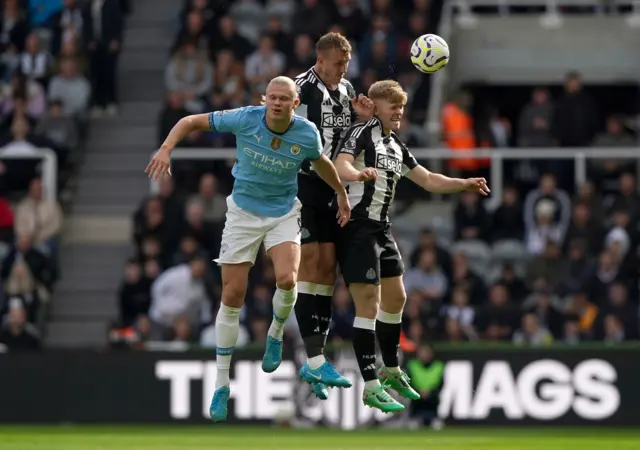 Manchester City's Erling Haaland (left) battle with Newcastle United's Dan Burn (centre) and Lewis Hall compete for the ball