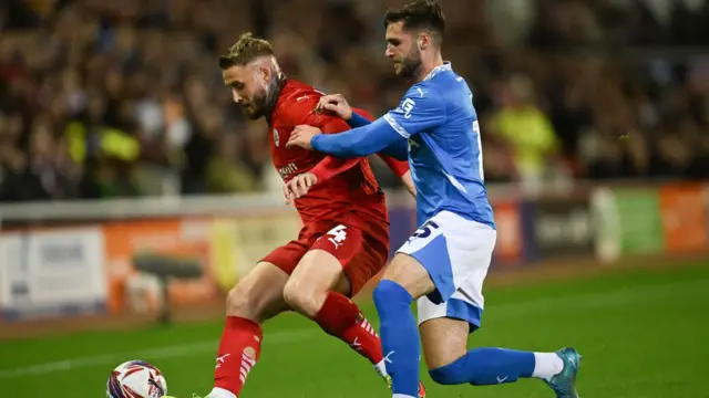 Barnsley's Stephen Humphrys holds off the challenge of Stockport's Ethan Pye