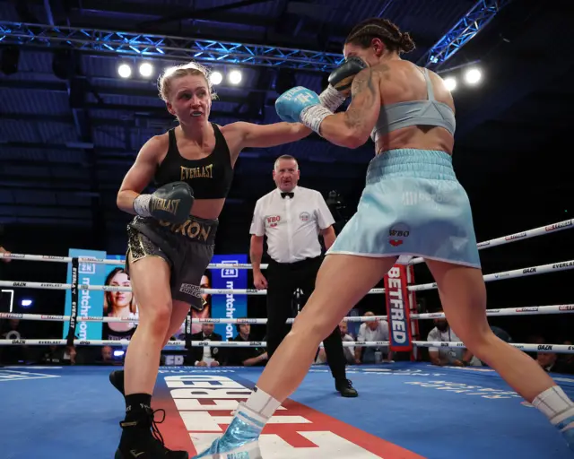 Rhiannon Dixon aims a punch at Terri Harper