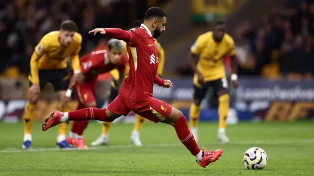 Mohamed Salah of Liverpool scores his team's second goal from the penalty-spot during the Premier League match between Wolverhampton Wanderers FC and Liverpool FC at Molineux on September 28, 2024 in Wolverhampton, England.