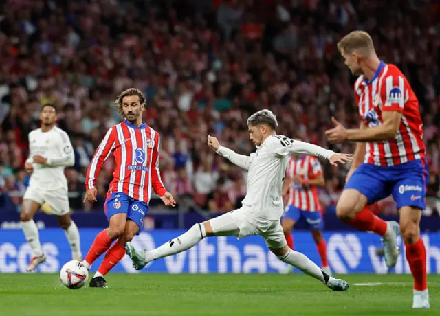 Antoine Griezmann (L) is challenged by Federico Valverde