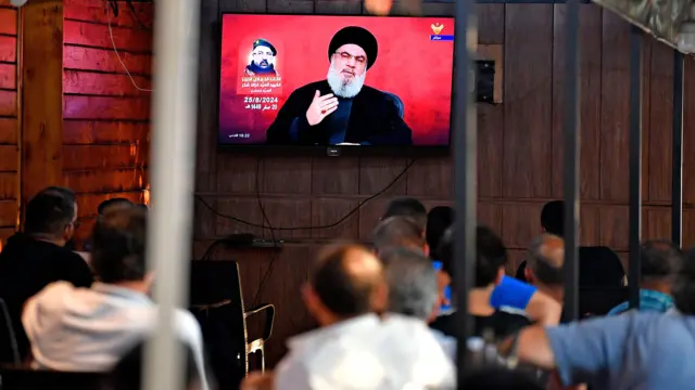 People watch Nasrallah delivering a televised speech at a coffee shop in the southern suburb of Beirut