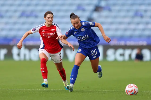 Missy Goodwin runs with the ball under pressure from Emily Fox