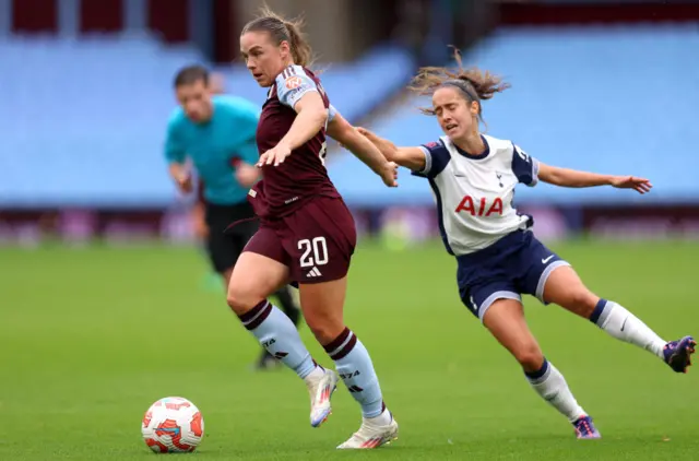 Kirsty Hanson runs with the ball whilst under pressure from Maite Oroz