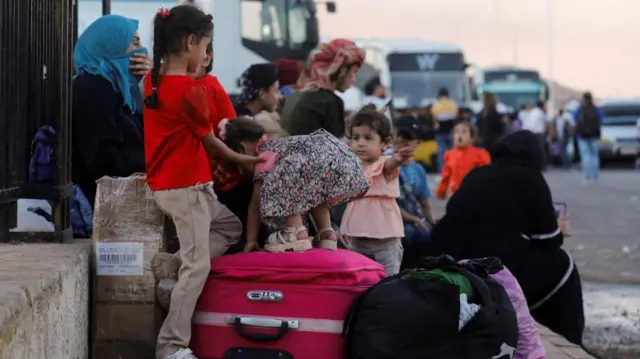 Syrians, who were living in Lebanon and returned to Syria due to ongoing hostilities between Hezbollah and Israeli forces, wait with their belongings at the Syrian-Lebanese border, in Jdaydet Yabous, Syria, September 25, 2024.