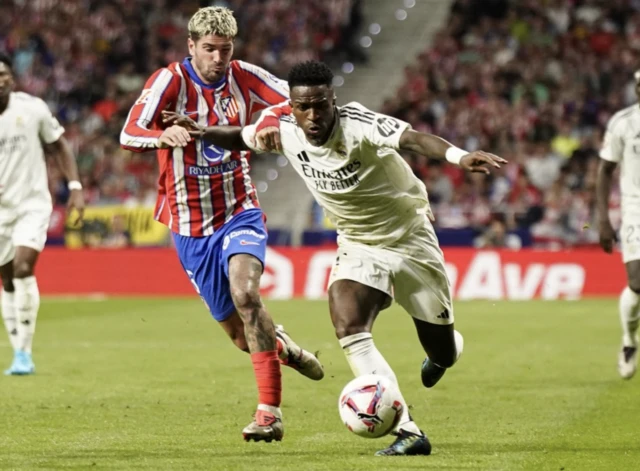 Vinicius Junior in action with Atletico Madrid's Rodrigo De Paul