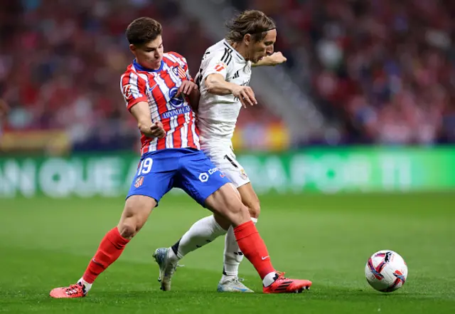 Luka Modric of Real Madrid is challenged by Julian Alvarez