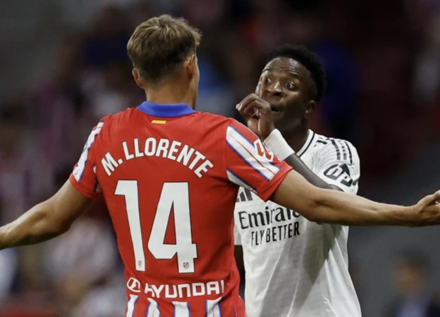 Real Madrid's Vinicius Junior and Atletico Madrid's Marcos Llorente react