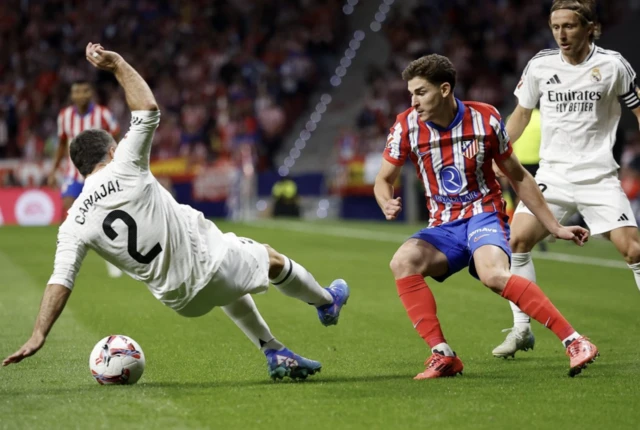 Real Madrid's Dani Carvajal and Luka Modric in action with Atletico Madrid's Julian Alvarez