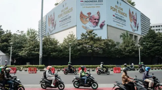 A welcome message for Pope Francis is displayed on an electric billboard at a roundabout in Jakarta