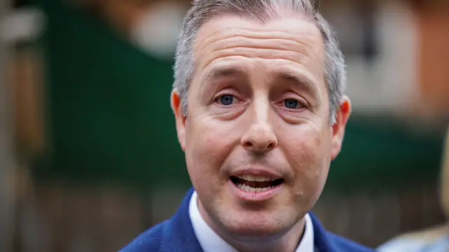 A man with grey hair wearing a blue suit