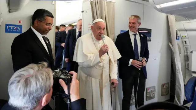 Pope Francis talks to journalists aboard the flight bound for Jakarta